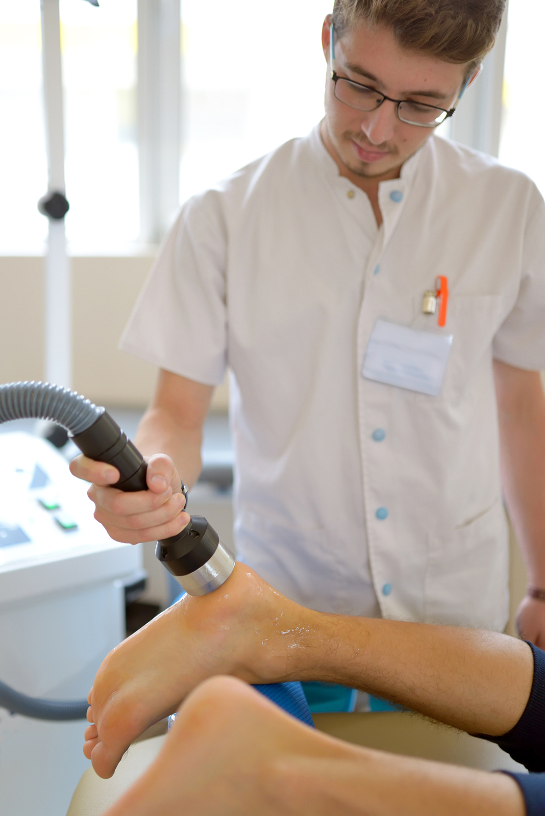 Physical therapist performs low level laser treatment on a patient's plantar fascia